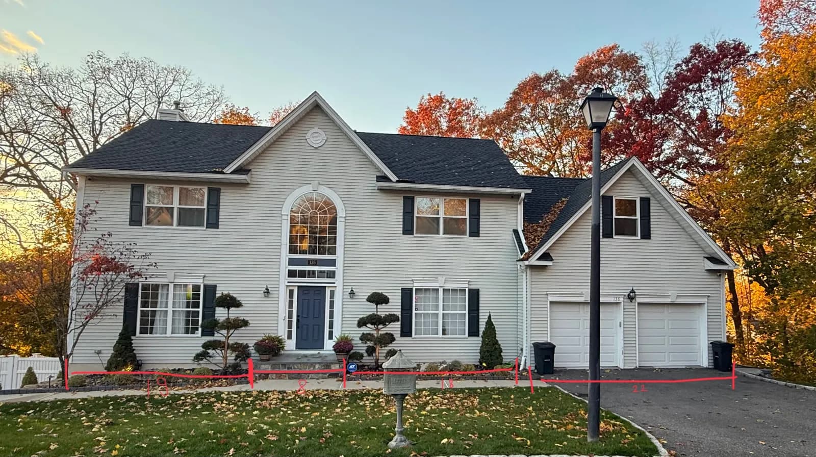 Patrick Avenue — Front elevation — dated beige vinyl colonial reborn as a modern white-stucco, stone, and dark-wood facade — before