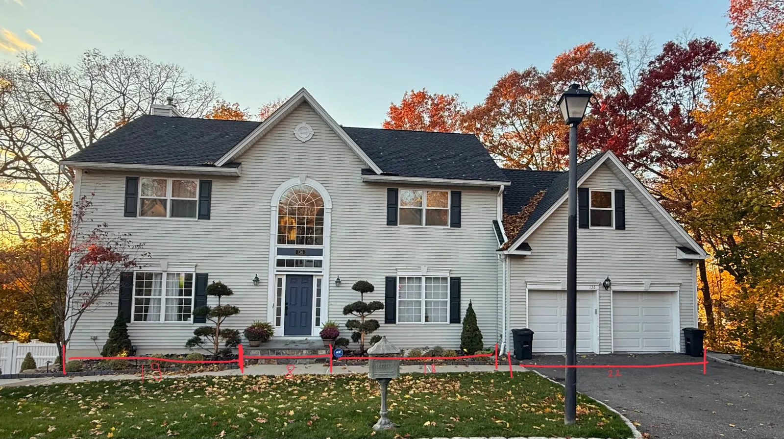 Patrick Avenue — Front elevation — dated beige vinyl colonial reborn as a modern white-stucco, stone, and dark-wood facade — before