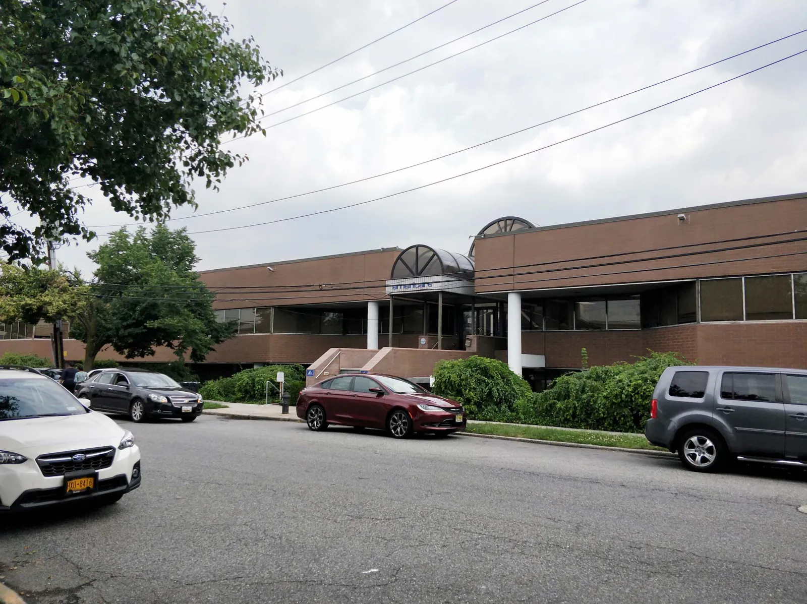 2275 Coleman Street — Building facade and main entrance — dated arched canopy reimagined as the modern Coleman Office Center storefront — before
