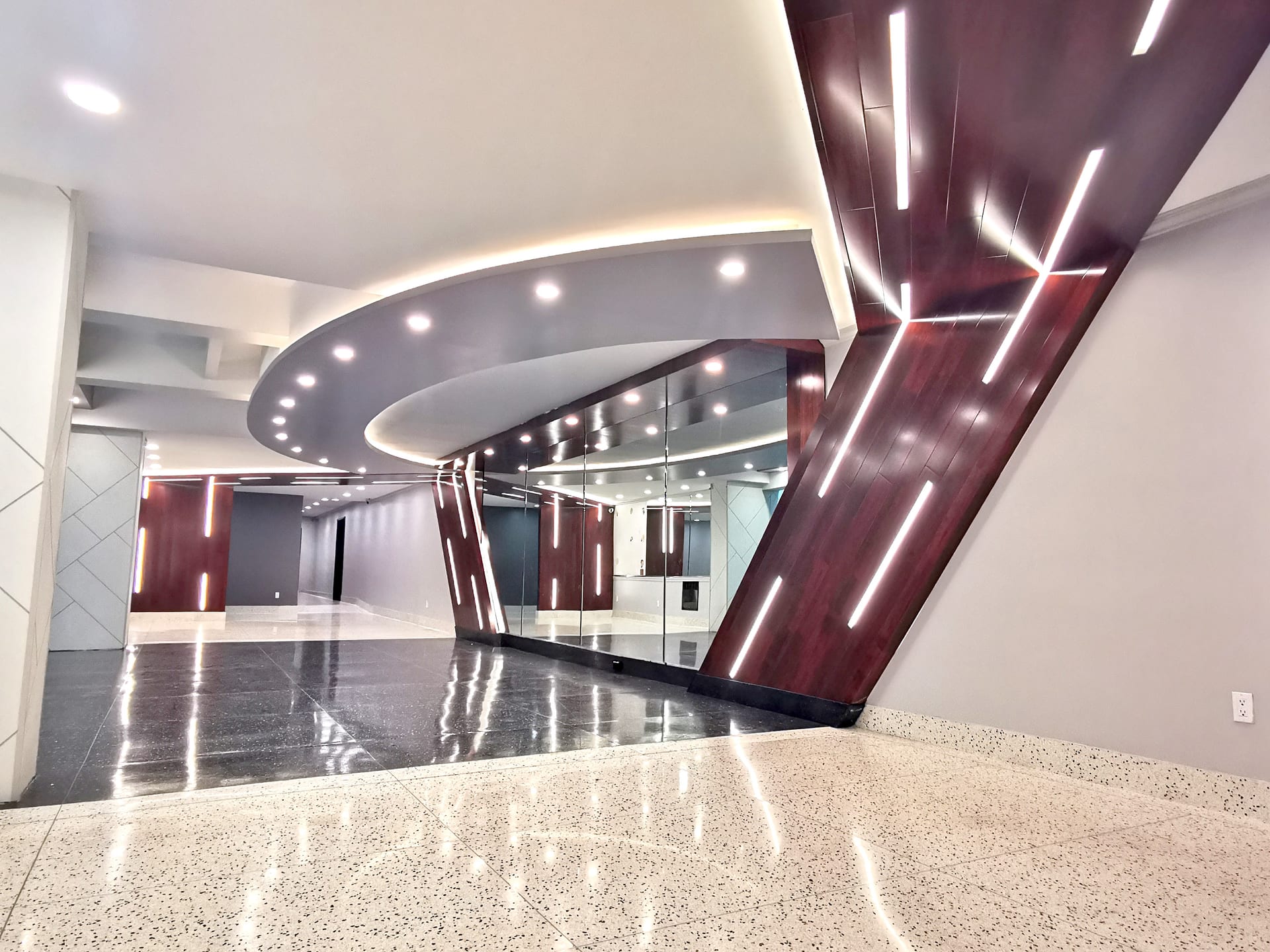 The Royale lobby renovation at 30 Bay 29th Street, Brooklyn — curved mahogany feature wall with backlit detailing