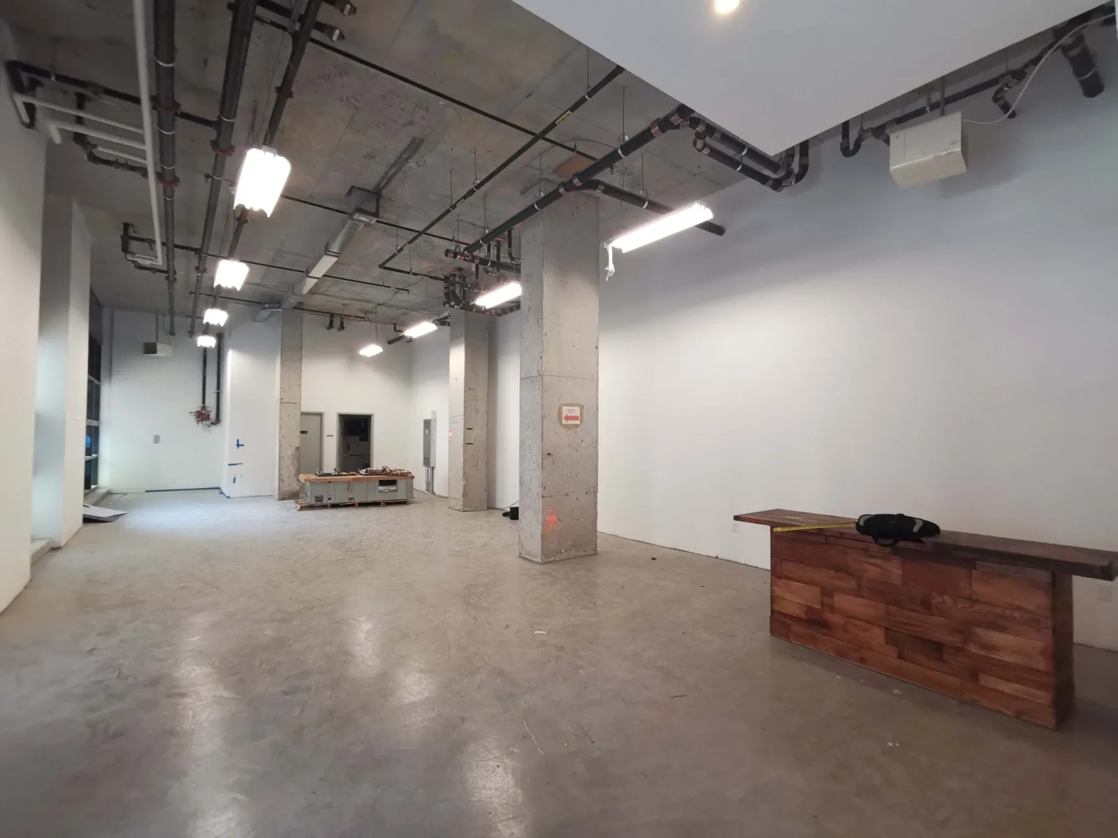 3002 39th Avenue — Main sales floor — from raw concrete shell to a finished retail showroom with full bottle-display walls and service counter. — before